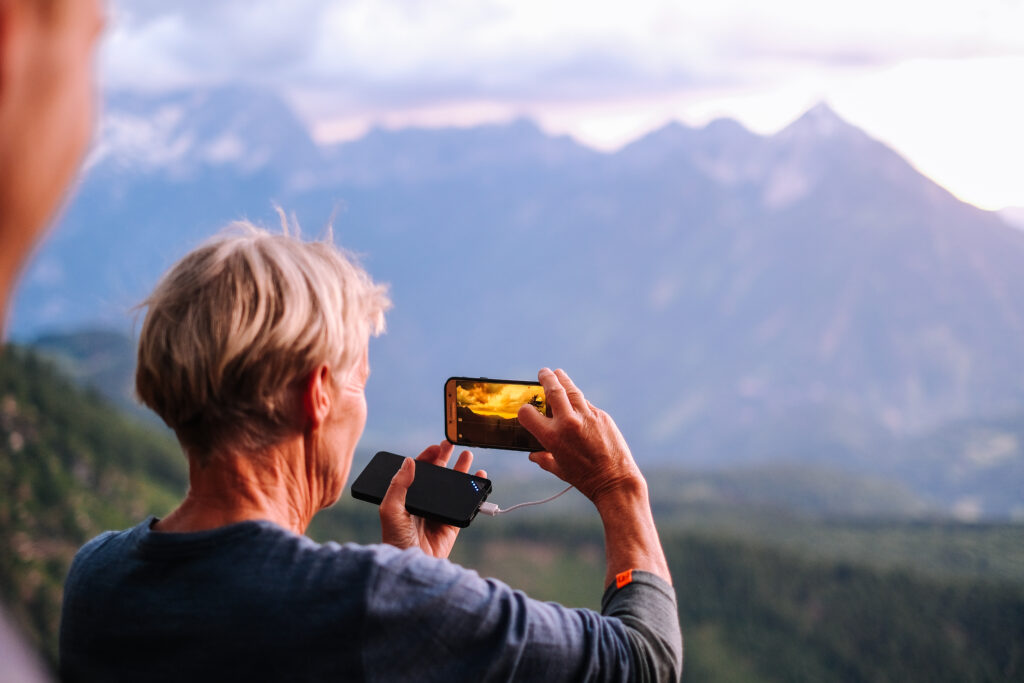Frau filmt mit dem Smartphone das Bergpanorama